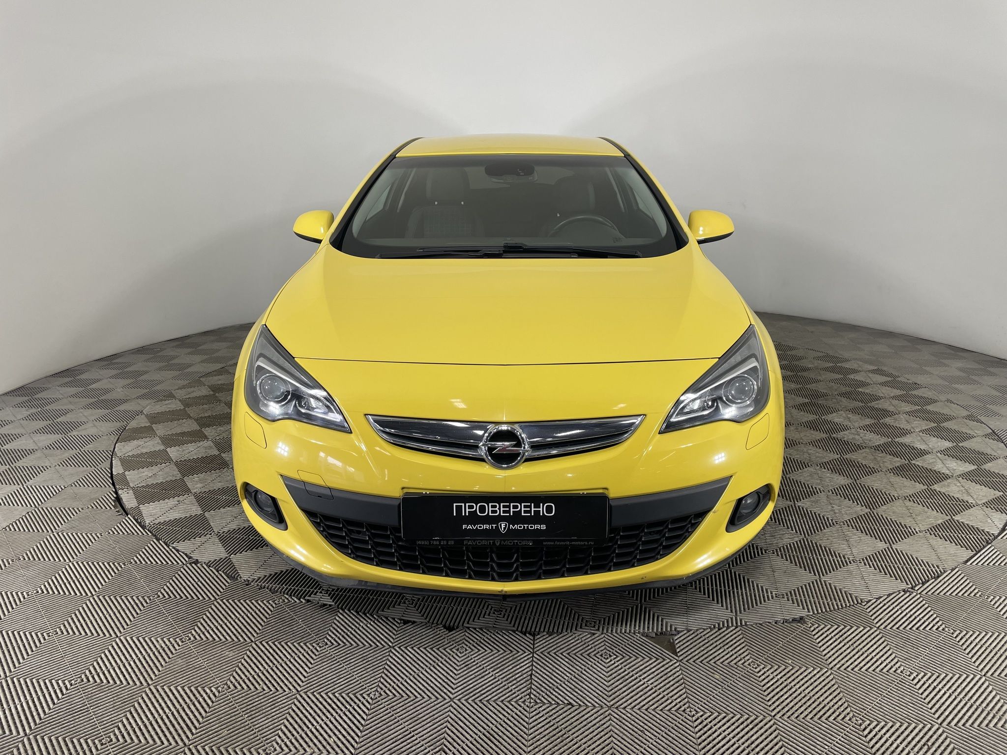 Opel Astra J GTC car in yellow vinyl film parked on the street in the city